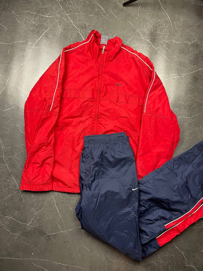 Nike red tracksuit jacket with white piping and navy pants with red trim.