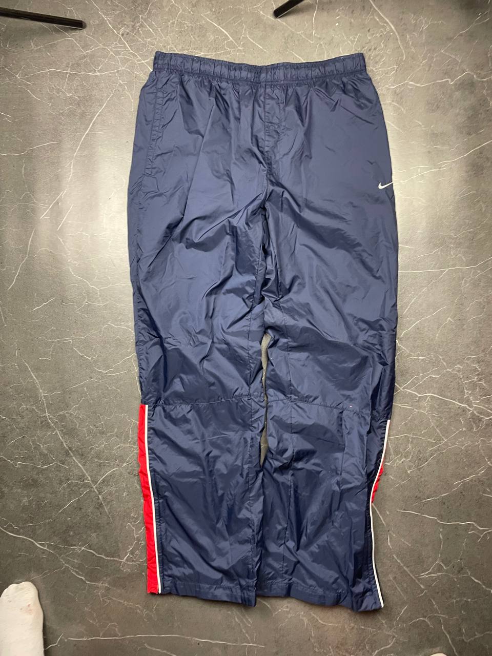 Nike red tracksuit jacket with white piping and navy pants with red trim.
