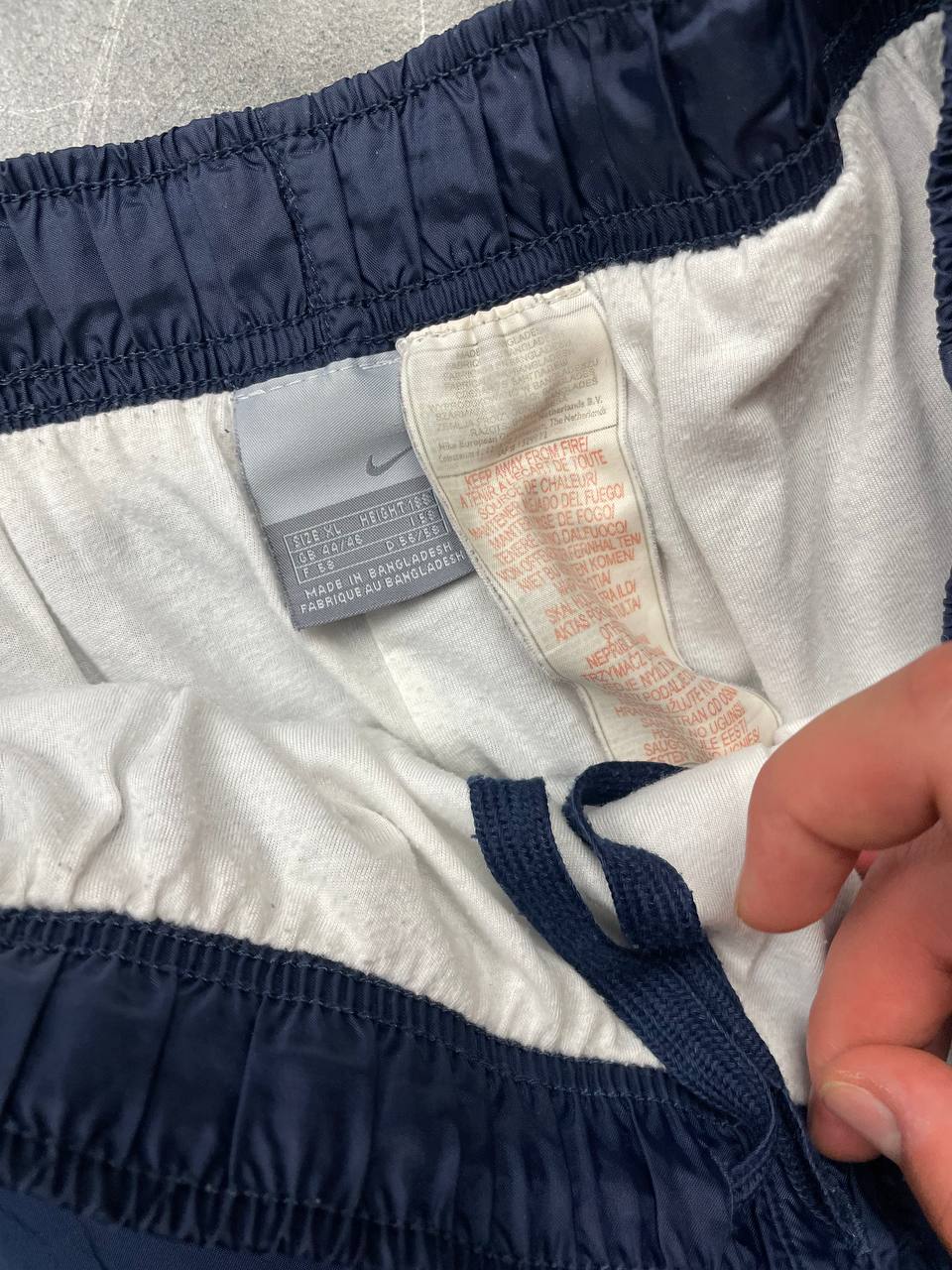 Nike red tracksuit jacket with white piping and navy pants with red trim.