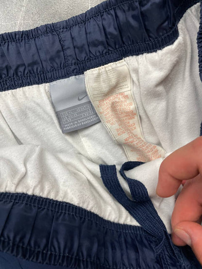 Nike red tracksuit jacket with white piping and navy pants with red trim.