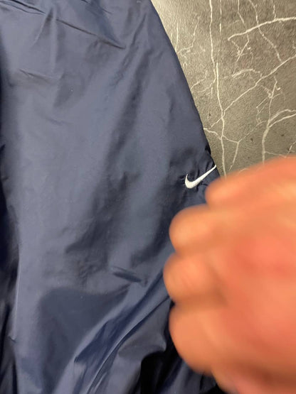 Nike red tracksuit jacket with white piping and navy pants with red trim.