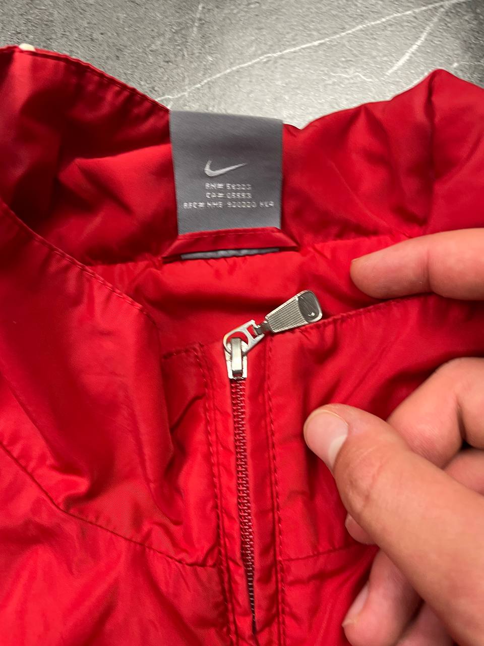 Nike red tracksuit jacket with white piping and navy pants with red trim.