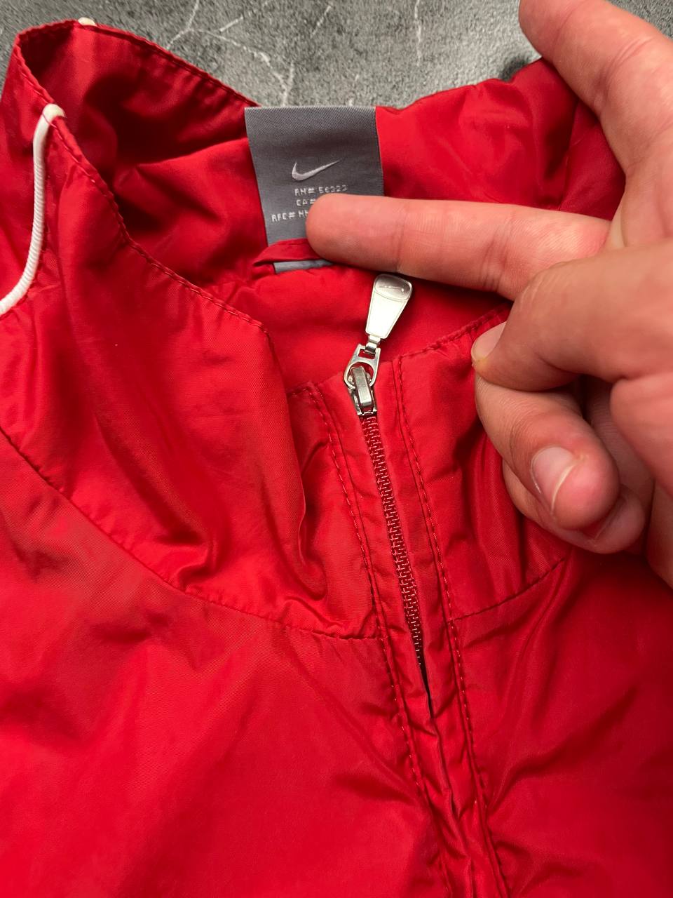 Nike red tracksuit jacket with white piping and navy pants with red trim.