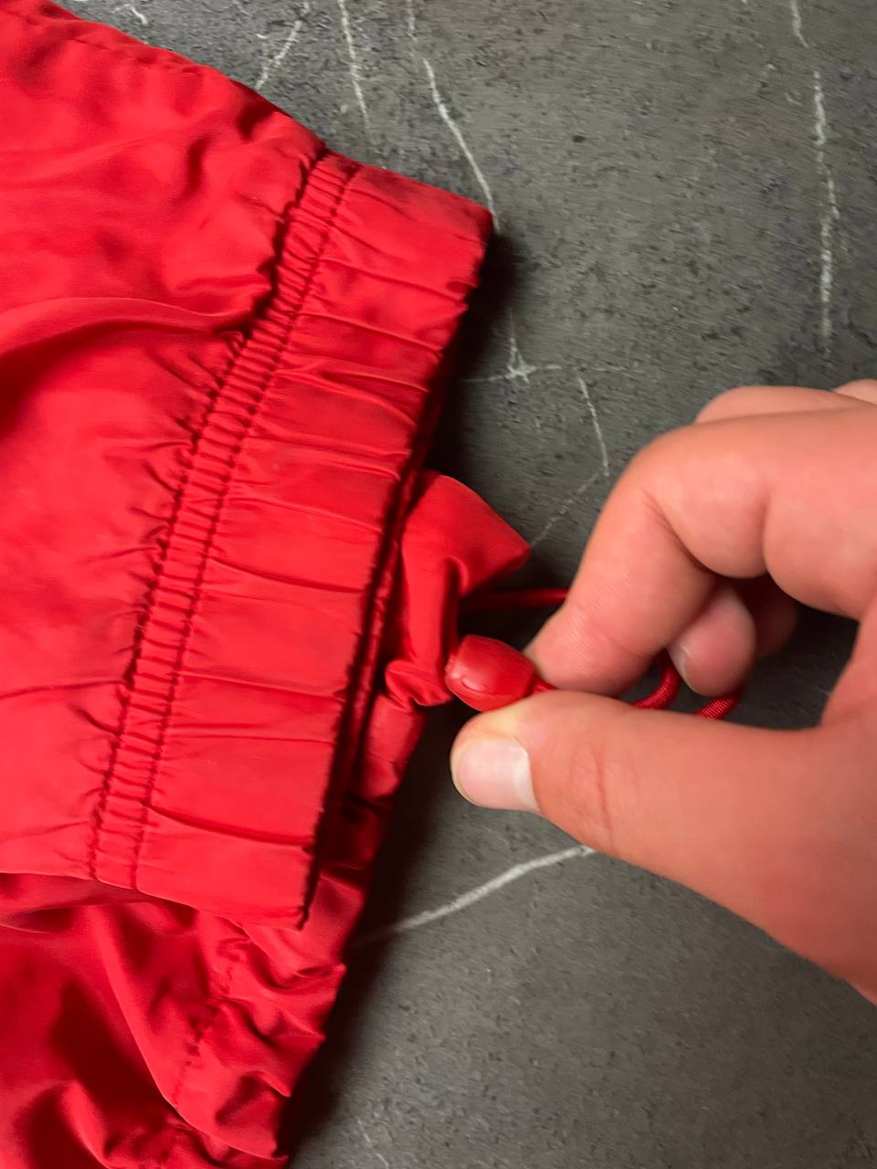 Nike red tracksuit jacket with white piping and navy pants with red trim.