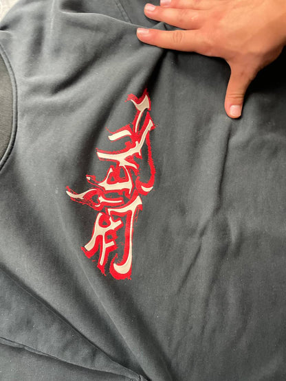 Vintage black crewneck sweatshirt with red and white embroidered logo and striped hem.