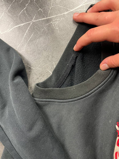 Vintage black crewneck sweatshirt with red and white embroidered logo and striped hem.
