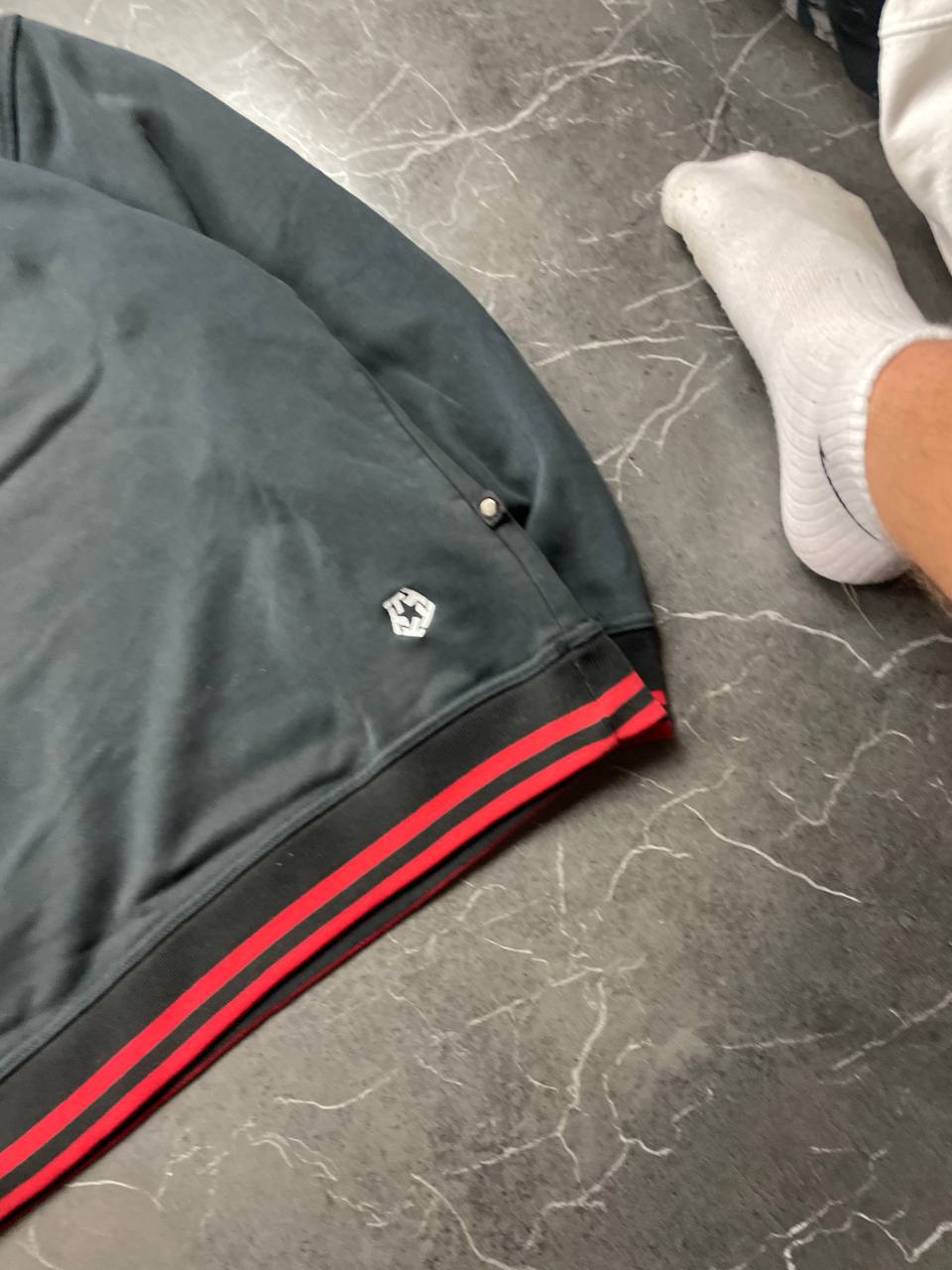 Vintage black crewneck sweatshirt with red and white embroidered logo and striped hem.
