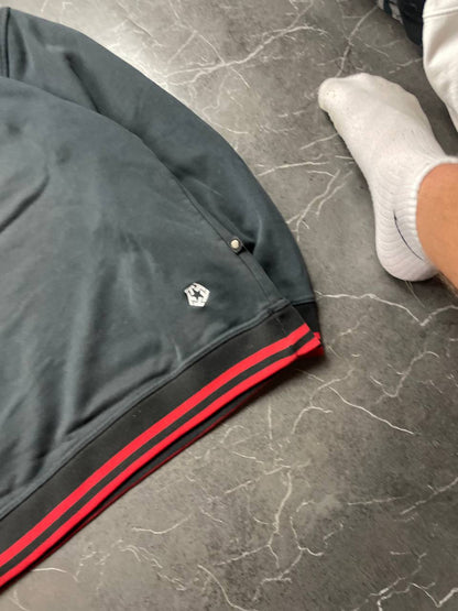Vintage black crewneck sweatshirt with red and white embroidered logo and striped hem.