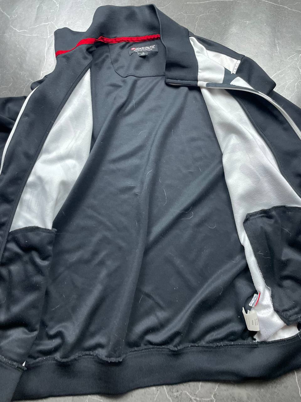 Ecko Unltd black zip-up jacket with graffiti print and spray paint can details.