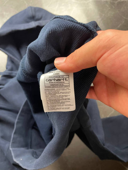 Carhartt navy hooded sweatshirt with American script logo on front left chest.