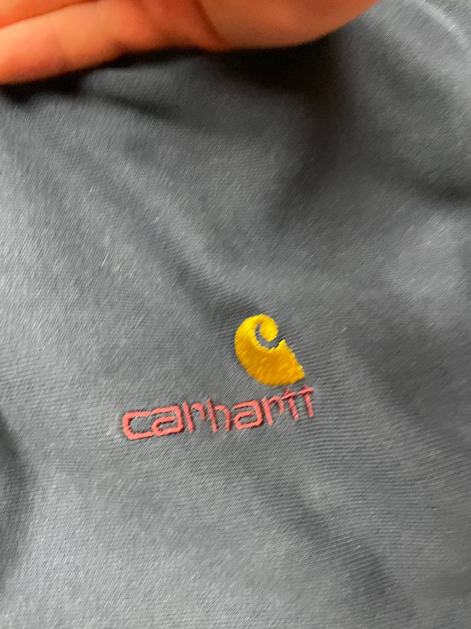 Carhartt navy hooded sweatshirt with American script logo on front left chest.