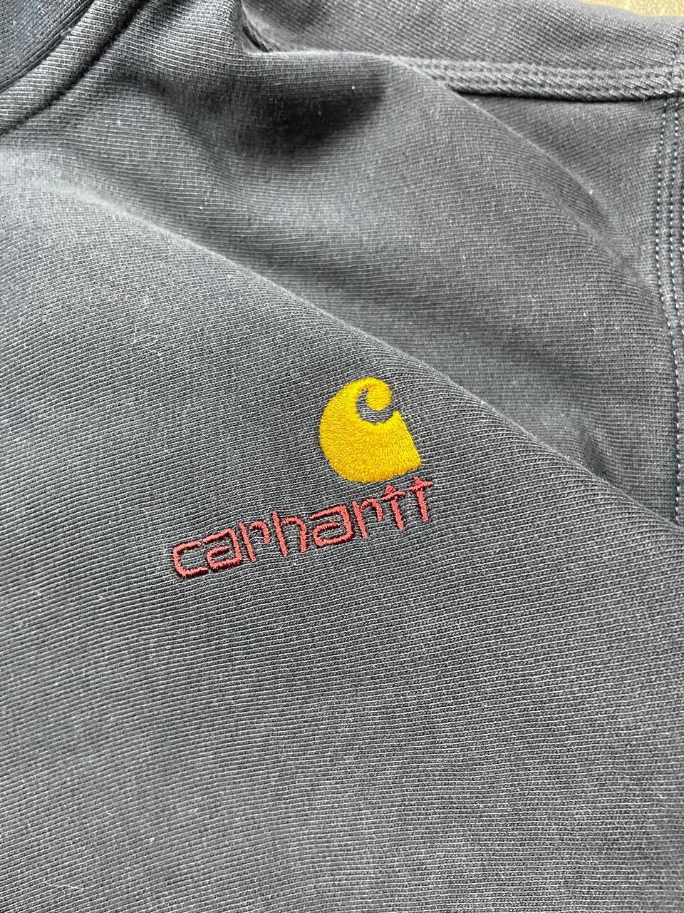 Carhartt navy hooded sweatshirt with American script logo on front left chest.