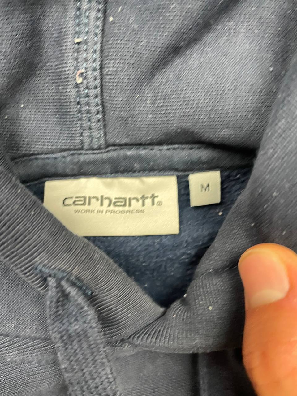 Carhartt navy hooded sweatshirt with American script logo on front left chest.
