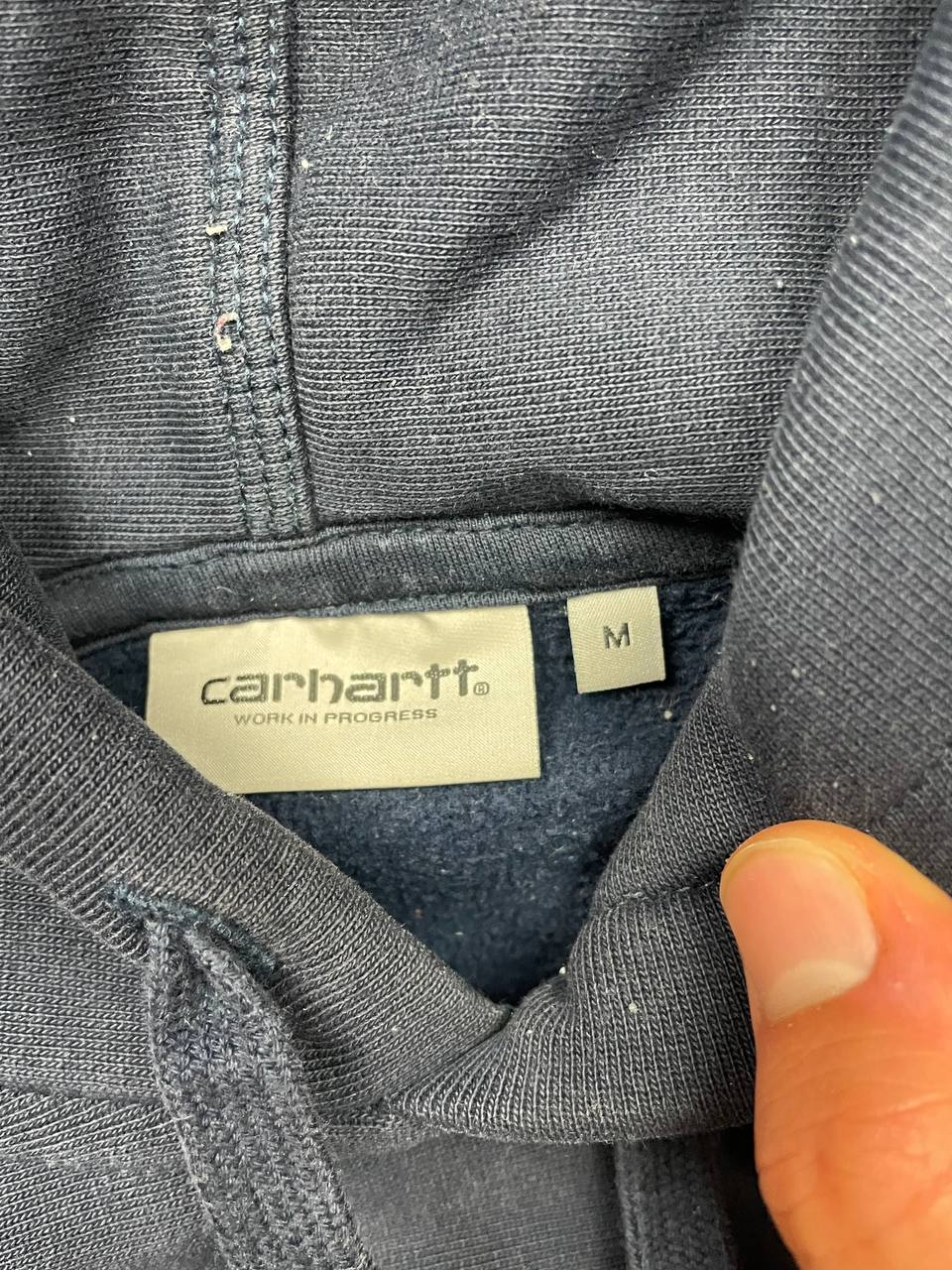 Carhartt navy hooded sweatshirt with American script logo on front left chest.