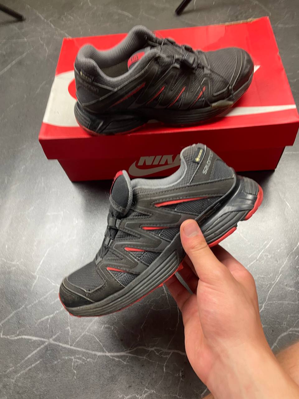 Salomon black and red trail running shoes with quick-lace closure and breathable mesh upper.
