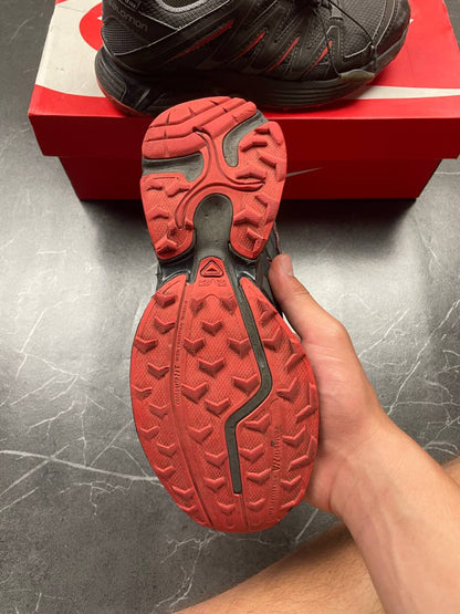 Salomon black and red trail running shoes with quick-lace closure and breathable mesh upper.