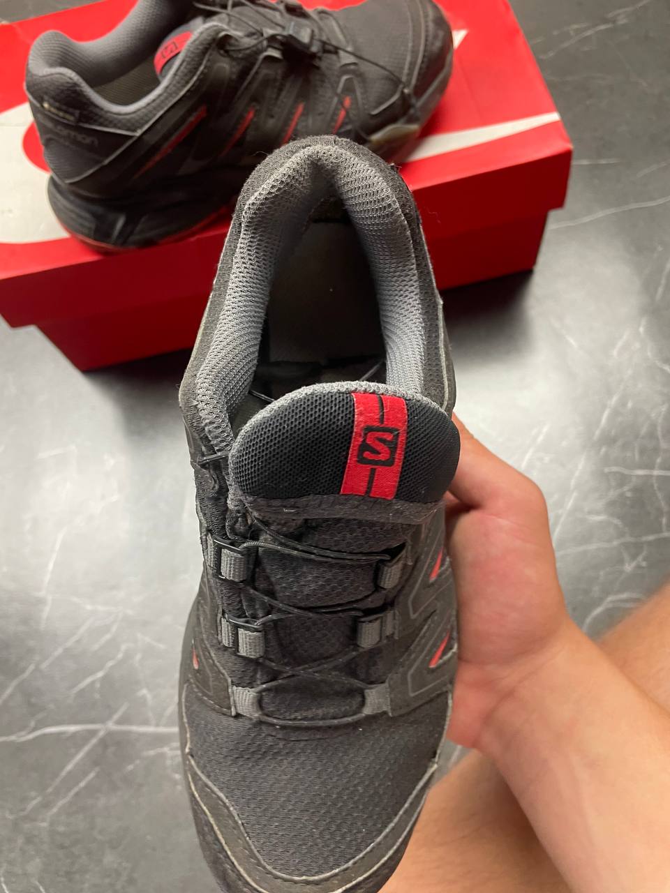 Salomon black and red trail running shoes with quick-lace closure and breathable mesh upper.