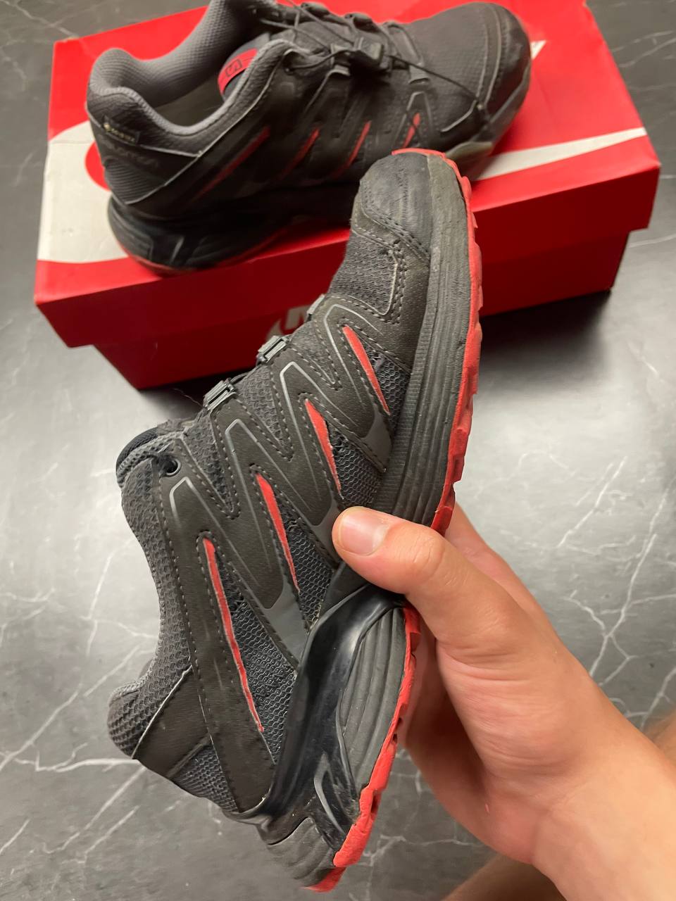 Salomon black and red trail running shoes with quick-lace closure and breathable mesh upper.