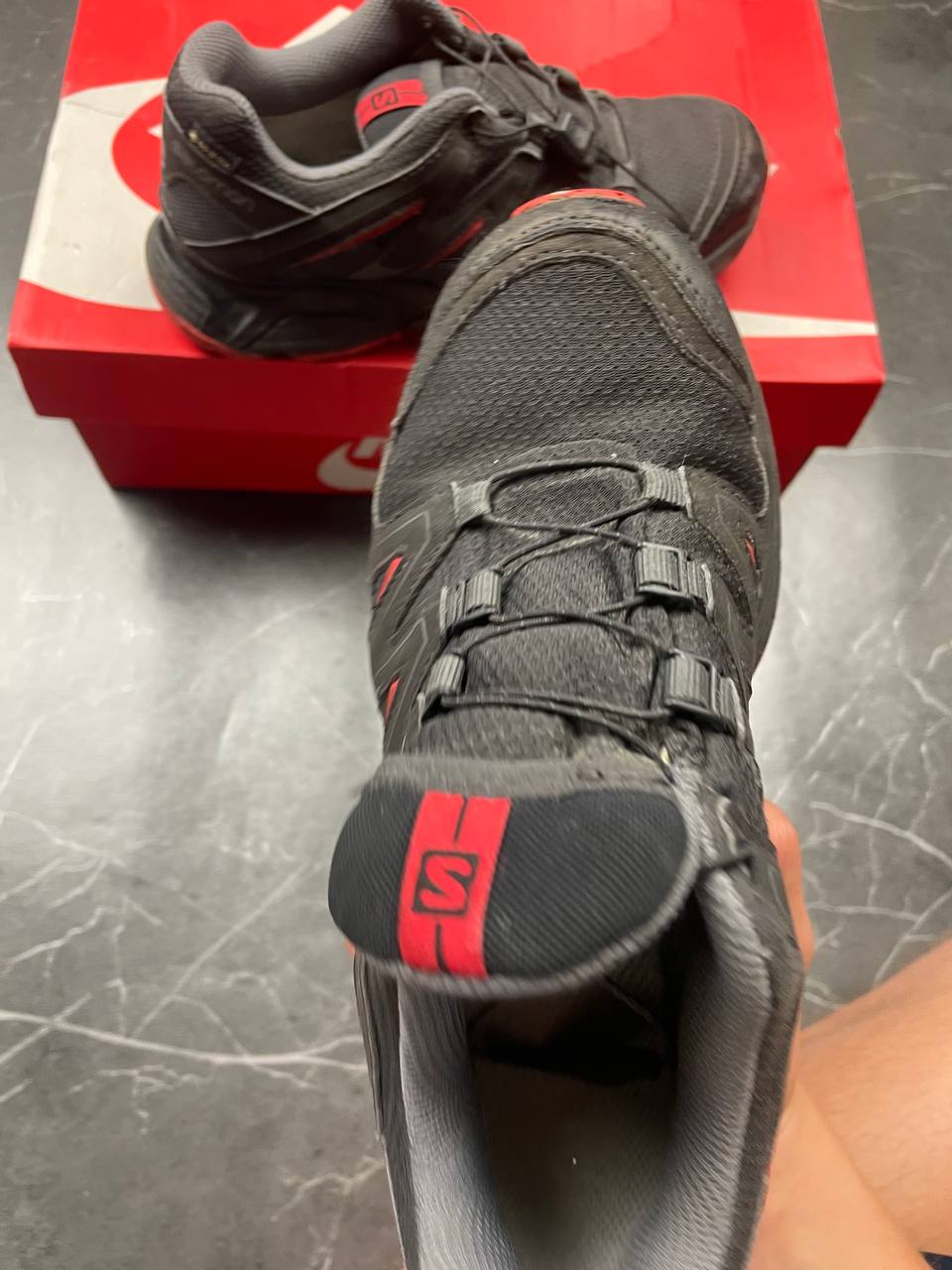 Salomon black and red trail running shoes with quick-lace closure and breathable mesh upper.