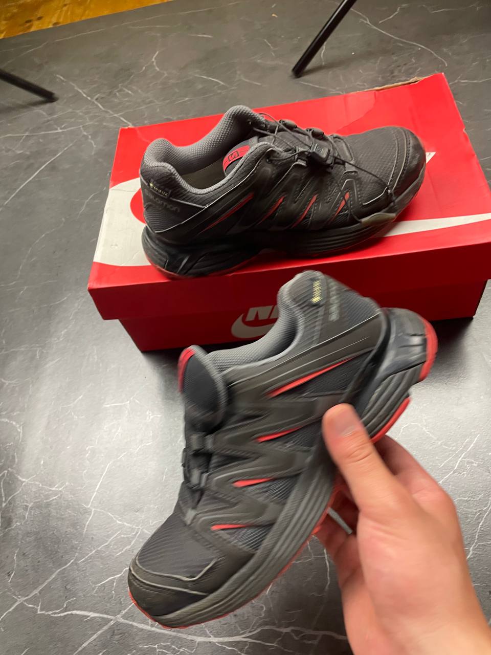 Salomon black and red trail running shoes with quick-lace closure and breathable mesh upper.