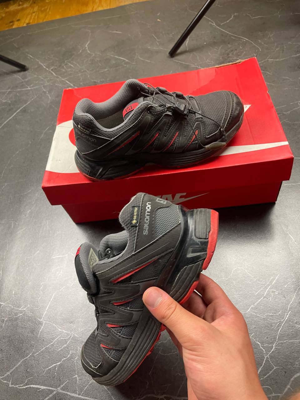 Salomon black and red trail running shoes with quick-lace closure and breathable mesh upper.