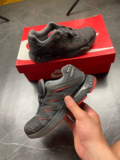 Salomon black and red trail running shoes with quick-lace closure and breathable mesh upper.