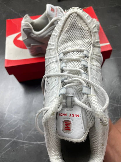 Nike silver and white running shoes with mesh upper and visible Shox cushioning columns.