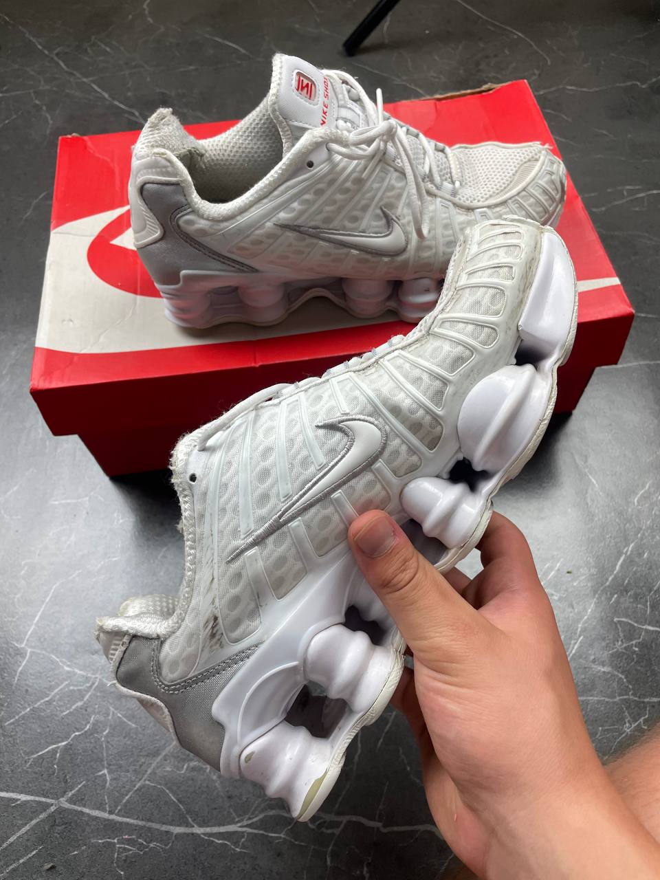 Nike silver and white running shoes with mesh upper and visible Shox cushioning columns.