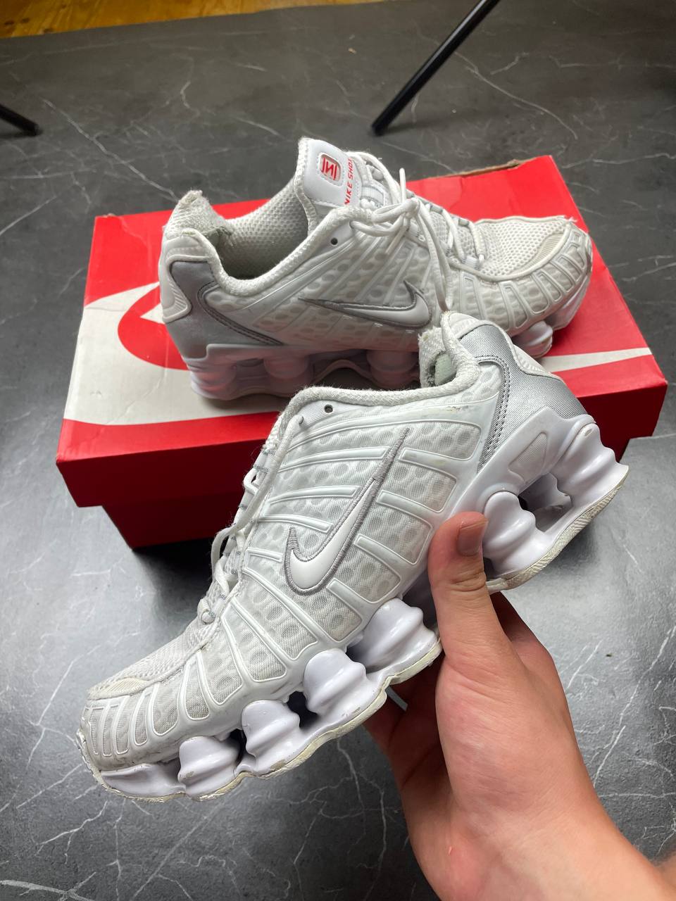Nike silver and white running shoes with mesh upper and visible Shox cushioning columns.