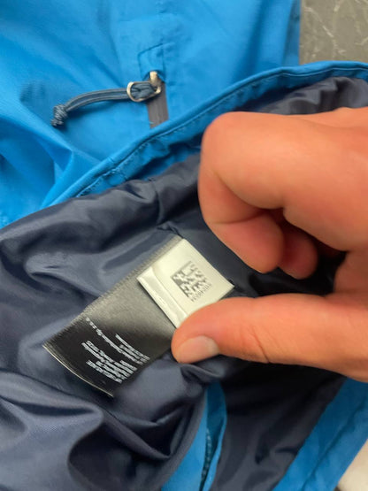 The North Face blue waterproof jacket with black accent panels and adjustable hood.