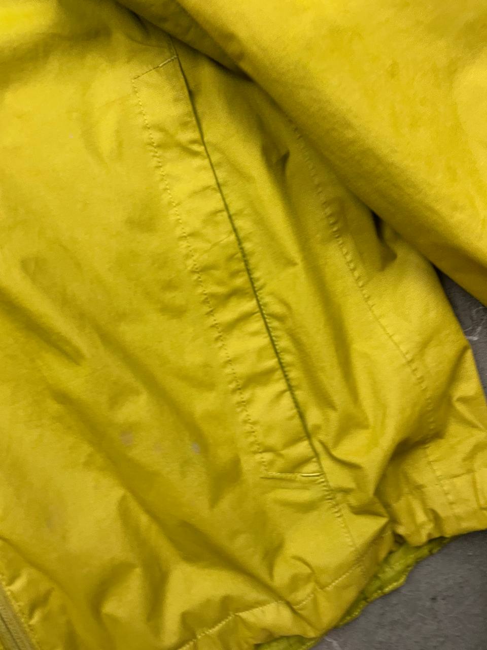 The North Face green hooded windbreaker jacket with branded patch and full zip front.