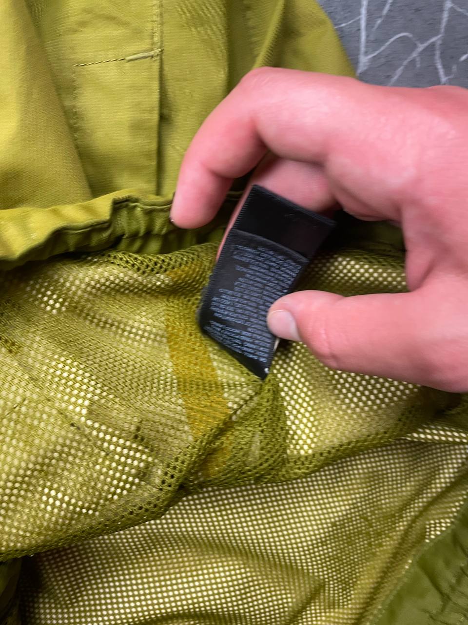 The North Face green hooded windbreaker jacket with branded patch and full zip front.