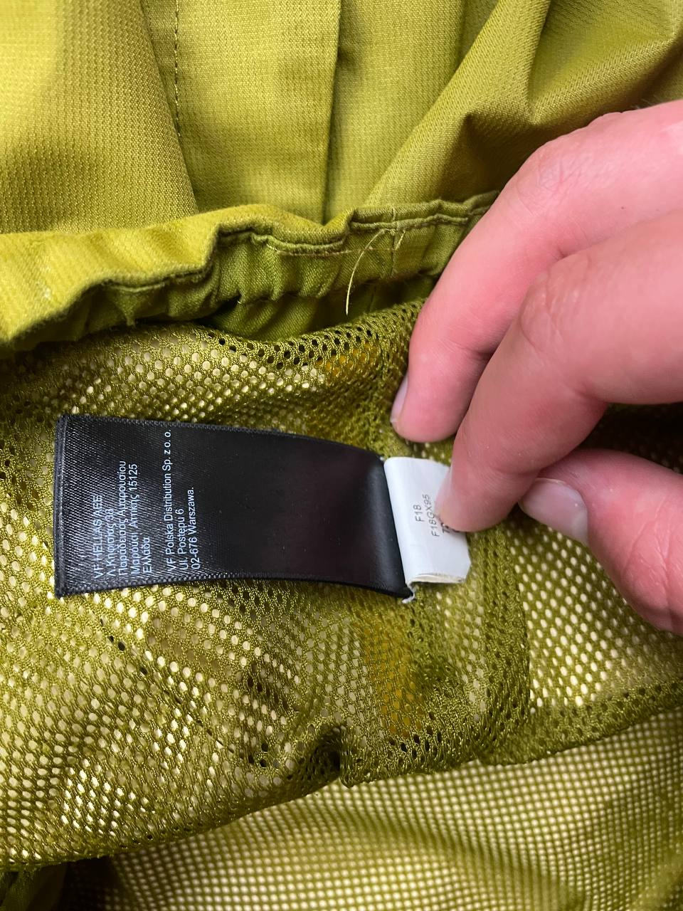 The North Face green hooded windbreaker jacket with branded patch and full zip front.
