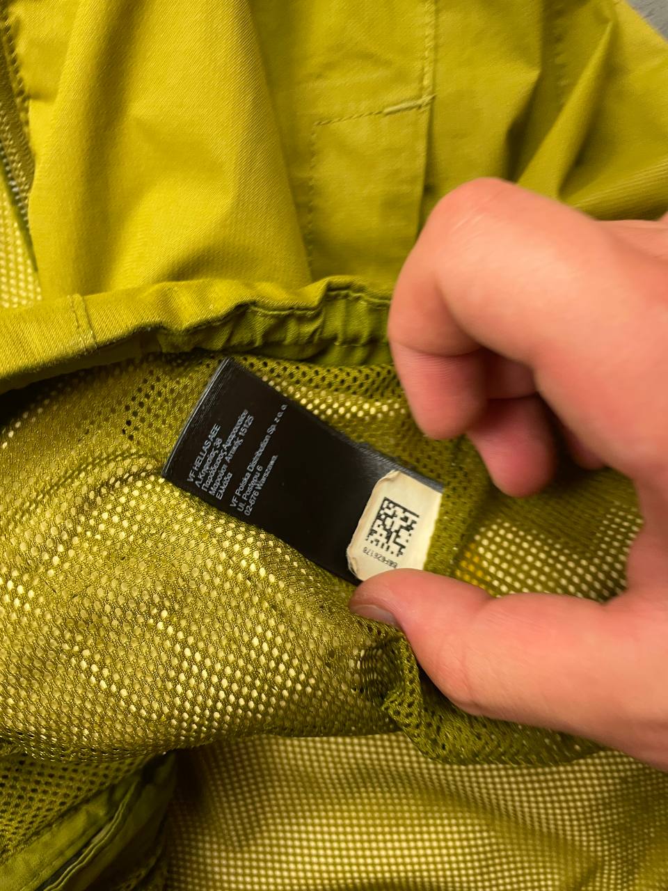 The North Face green hooded windbreaker jacket with branded patch and full zip front.