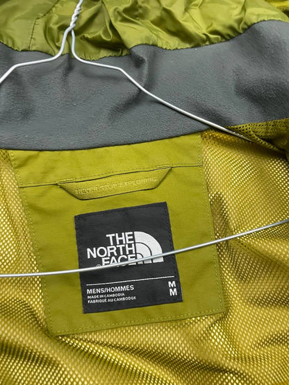 The North Face green hooded windbreaker jacket with branded patch and full zip front.