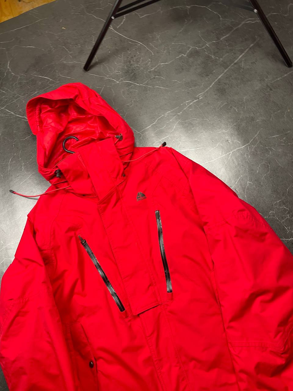 Nike red hooded jacket with waterproof zippers and adjustable hood, 100% polyester.