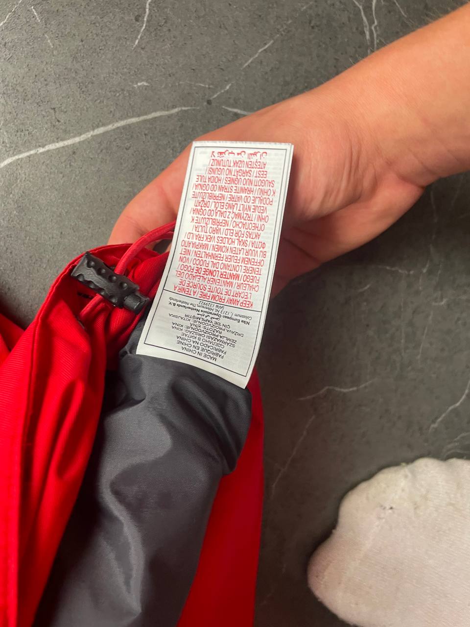 Nike red hooded jacket with waterproof zippers and adjustable hood, 100% polyester.
