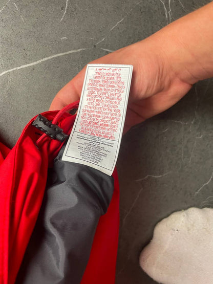 Nike red hooded jacket with waterproof zippers and adjustable hood, 100% polyester.