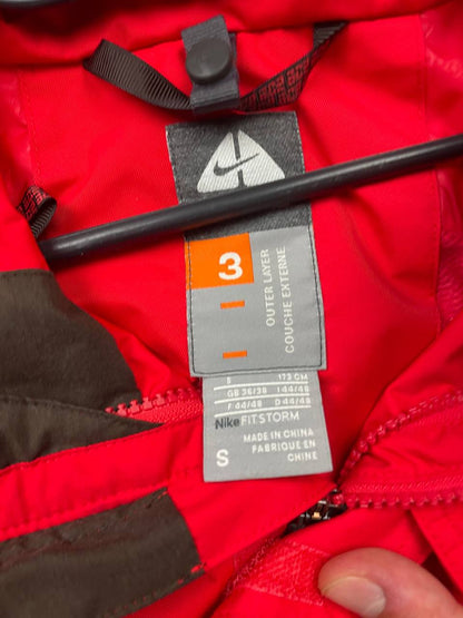 Nike red hooded jacket with waterproof zippers and adjustable hood, 100% polyester.