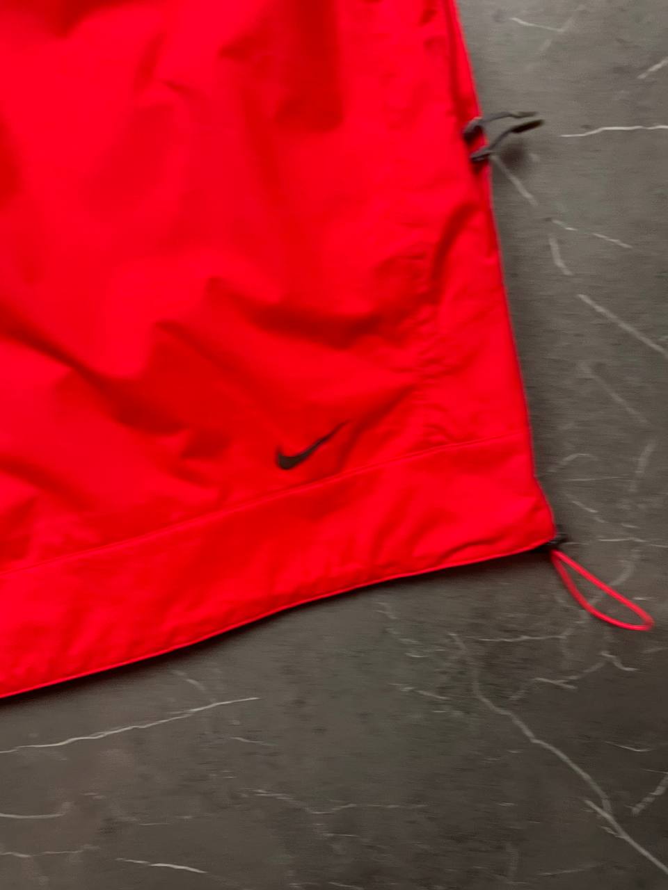 Nike red hooded jacket with waterproof zippers and adjustable hood, 100% polyester.