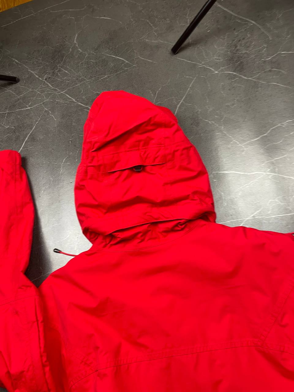 Nike red hooded jacket with waterproof zippers and adjustable hood, 100% polyester.