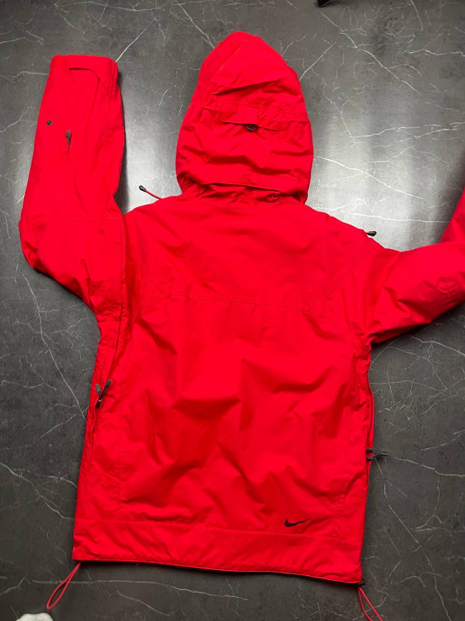 Nike red hooded jacket with waterproof zippers and adjustable hood, 100% polyester.