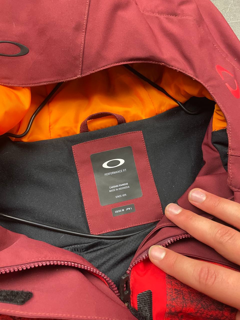 Oakley burgundy and red waterproof jacket with patterned accents and adjustable hood.