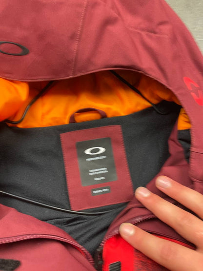 Oakley burgundy and red waterproof jacket with patterned accents and adjustable hood.