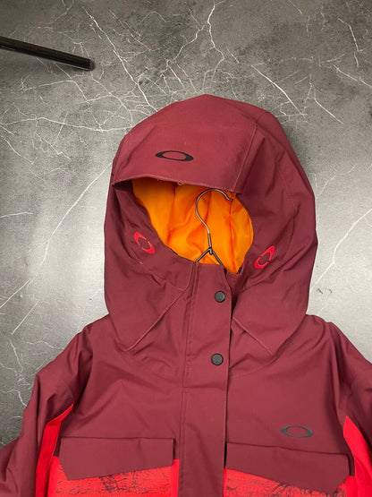 Oakley burgundy and red waterproof jacket with patterned accents and adjustable hood.