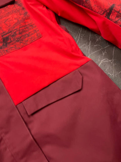 Oakley burgundy and red waterproof jacket with patterned accents and adjustable hood.
