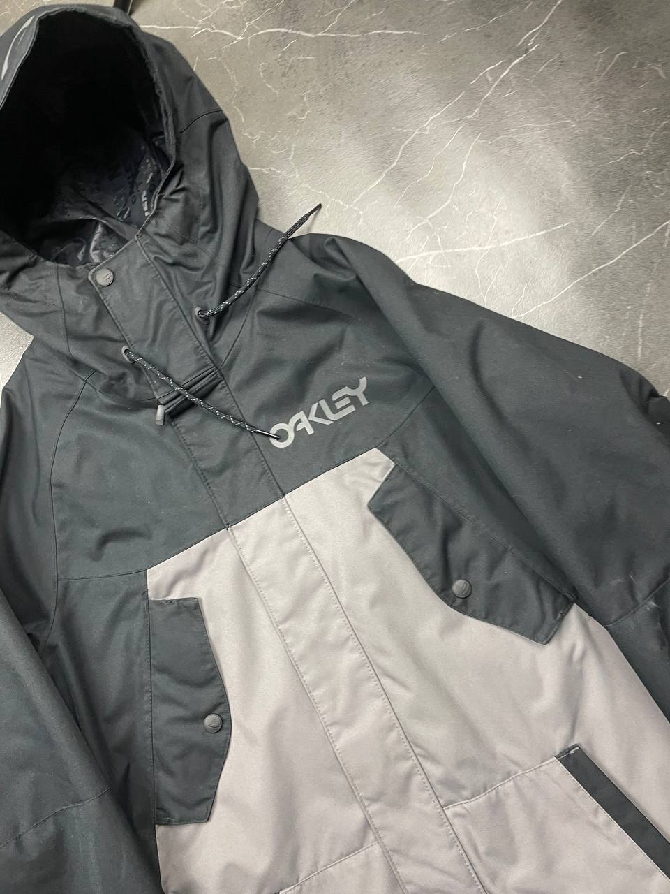 Oakley insulated hooded jacket black and grey with logo on chest and hood.