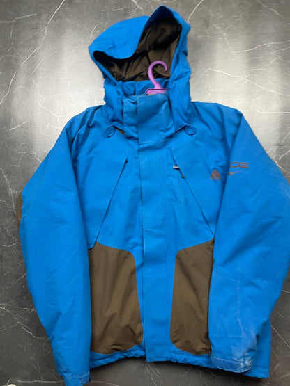 Nike ACG blue and brown waterproof jacket with Gore-Tex label and adjustable hood.