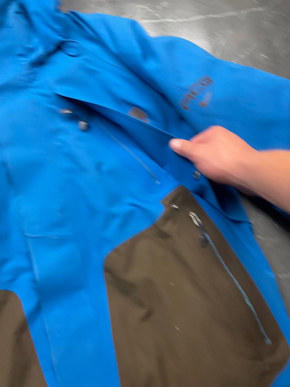 Nike ACG blue and brown waterproof jacket with Gore-Tex label and adjustable hood.