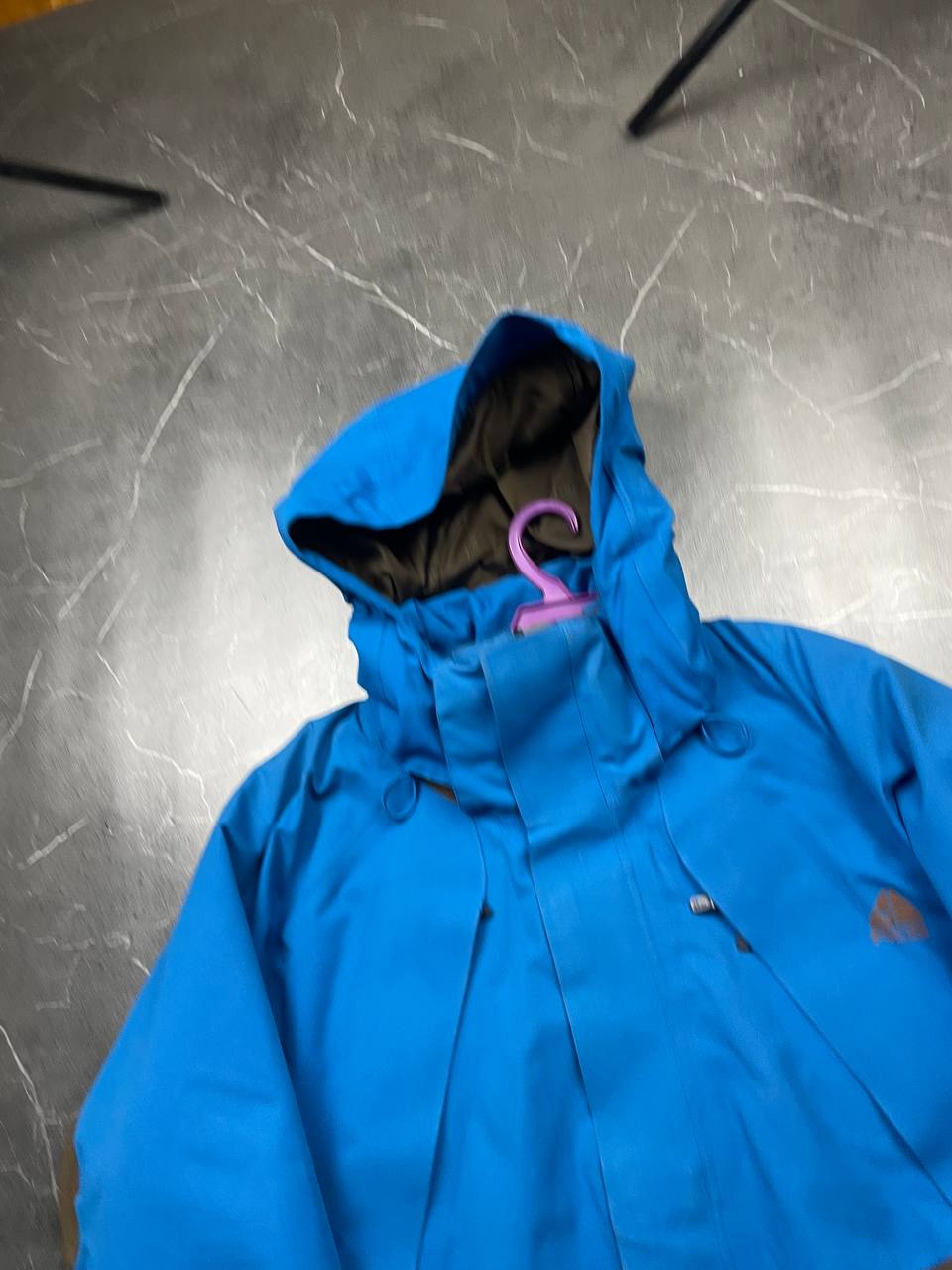 Nike ACG blue and brown waterproof jacket with Gore-Tex label and adjustable hood.